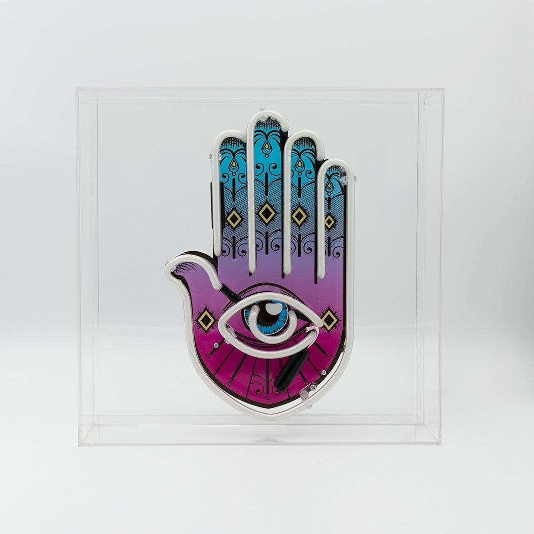 TOM NEON Glas Neon Box 'All Seeing Eye'. Einzigartiges Neondesign mit dem Motiv des allsehenden Auges, eingebettet in einer eleganten Glasbox. Perfekte Wahl für eine mystische und stilvolle Raumdekoration.