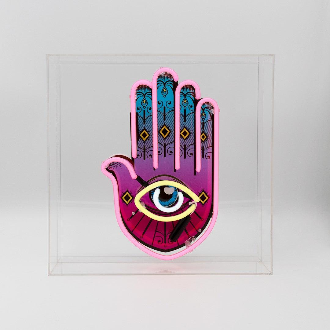 TOM NEON Glas Neon Box 'All Seeing Eye'. Einzigartiges Neondesign mit dem Motiv des allsehenden Auges, eingebettet in einer eleganten Glasbox. Perfekte Wahl für eine mystische und stilvolle Raumdekoration.