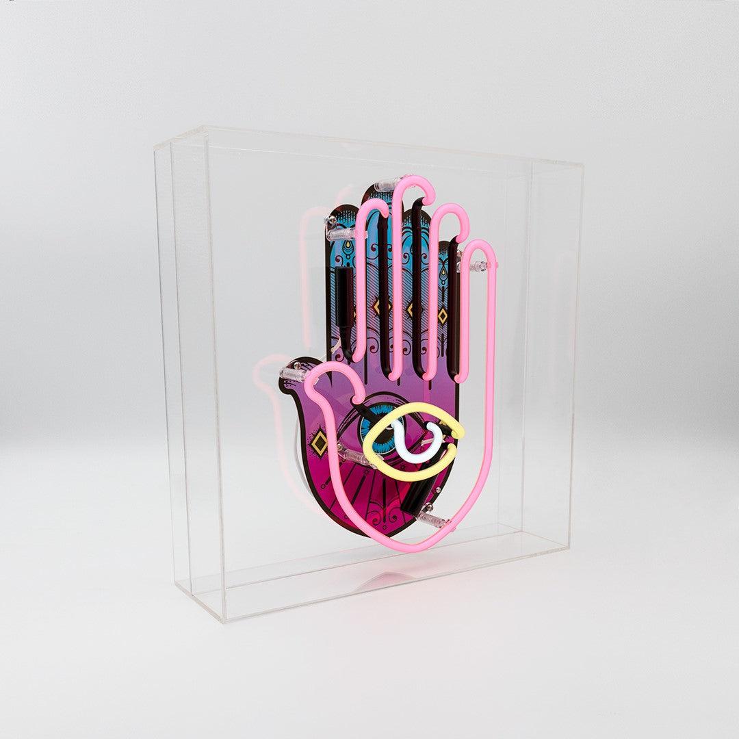 TOM NEON Glas Neon Box 'All Seeing Eye'. Einzigartiges Neondesign mit dem Motiv des allsehenden Auges, eingebettet in einer eleganten Glasbox. Perfekte Wahl für eine mystische und stilvolle Raumdekoration.