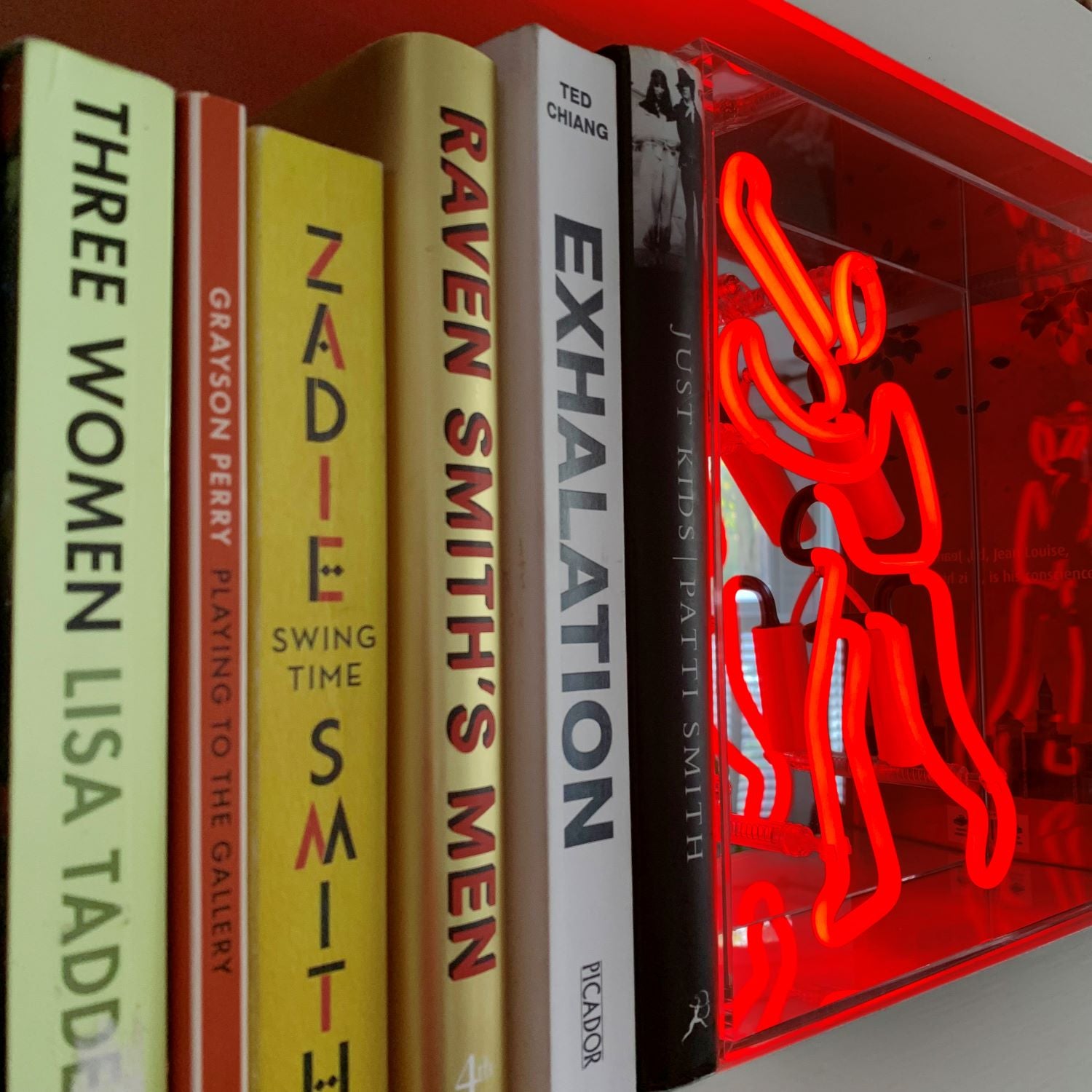 TOM NEON Glas Neon Box 'Buchmann'. Leuchtendes Neonlicht mit einem Buchmotiv, eingebettet in einer eleganten Glasbox. Perfekt für eine stilvolle und literarische Raumdekoration.