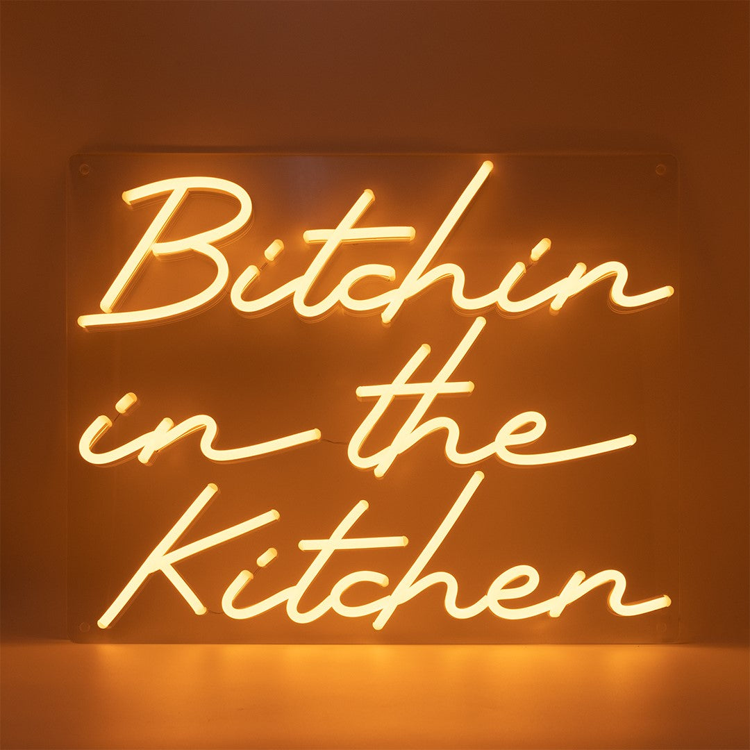 TOM NEON LED Schriftzug 'Bitchin in the Kitchen'. Leuchtender Neonschriftzug mit dem frechen Text 'Bitchin in the Kitchen' in stilvollen Buchstaben. Perfekt für eine moderne und humorvolle Küchendekoration.