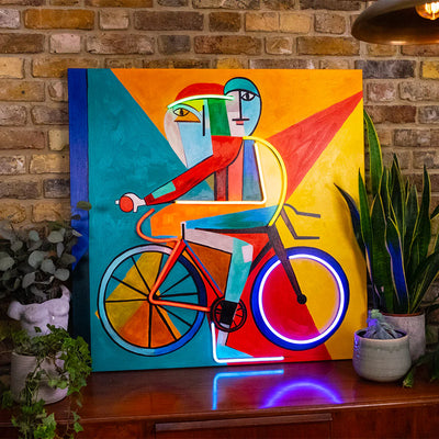 TOM NEON LED Wandkunst 'Abstract on Bike'. Moderner Neonschriftzug mit abstraktem Fahrraddesign in leuchtenden Farben. Perfekt für stilvolle Raumdekoration.