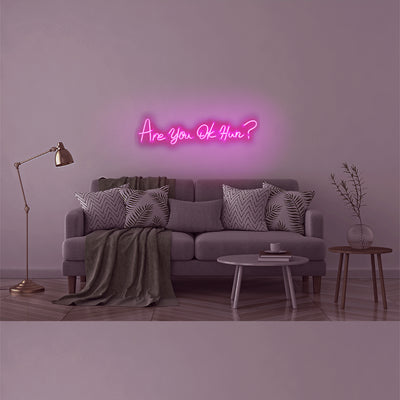 TOM NEON LED Schriftzug 'Are you ok Hun?'. Leuchtender Neonschriftzug mit der Frage 'Are you ok Hun?' in stilvollen Buchstaben. Ideal für moderne und ausdrucksstarke Raumgestaltung.